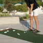PrimePutt putting mat on a sunny garden terrace, with a golfer putting a ball toward the cups